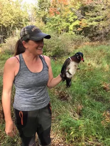 Female hunter holding drake woodduck